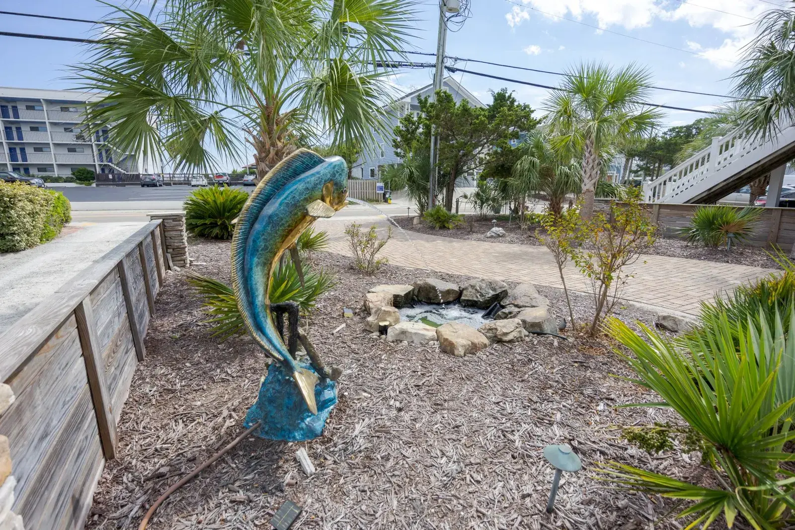 Gravel garden patio with sculpture and layered plantings