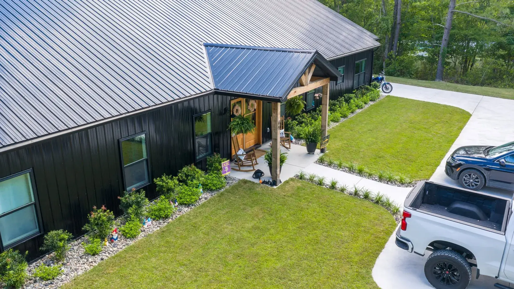 Fresh foundation plantings and stone border at a black board-and-batten home