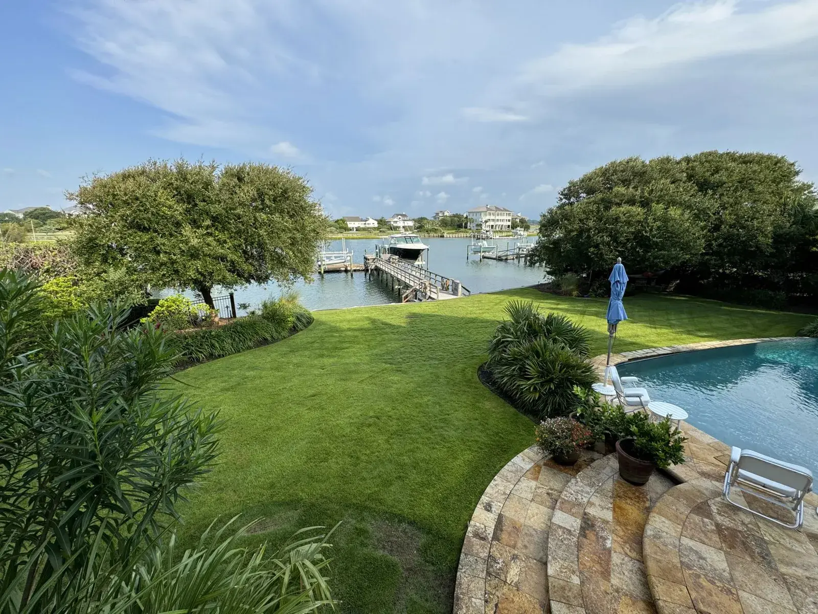 Poolside lawn and stone patio on a tidal creek