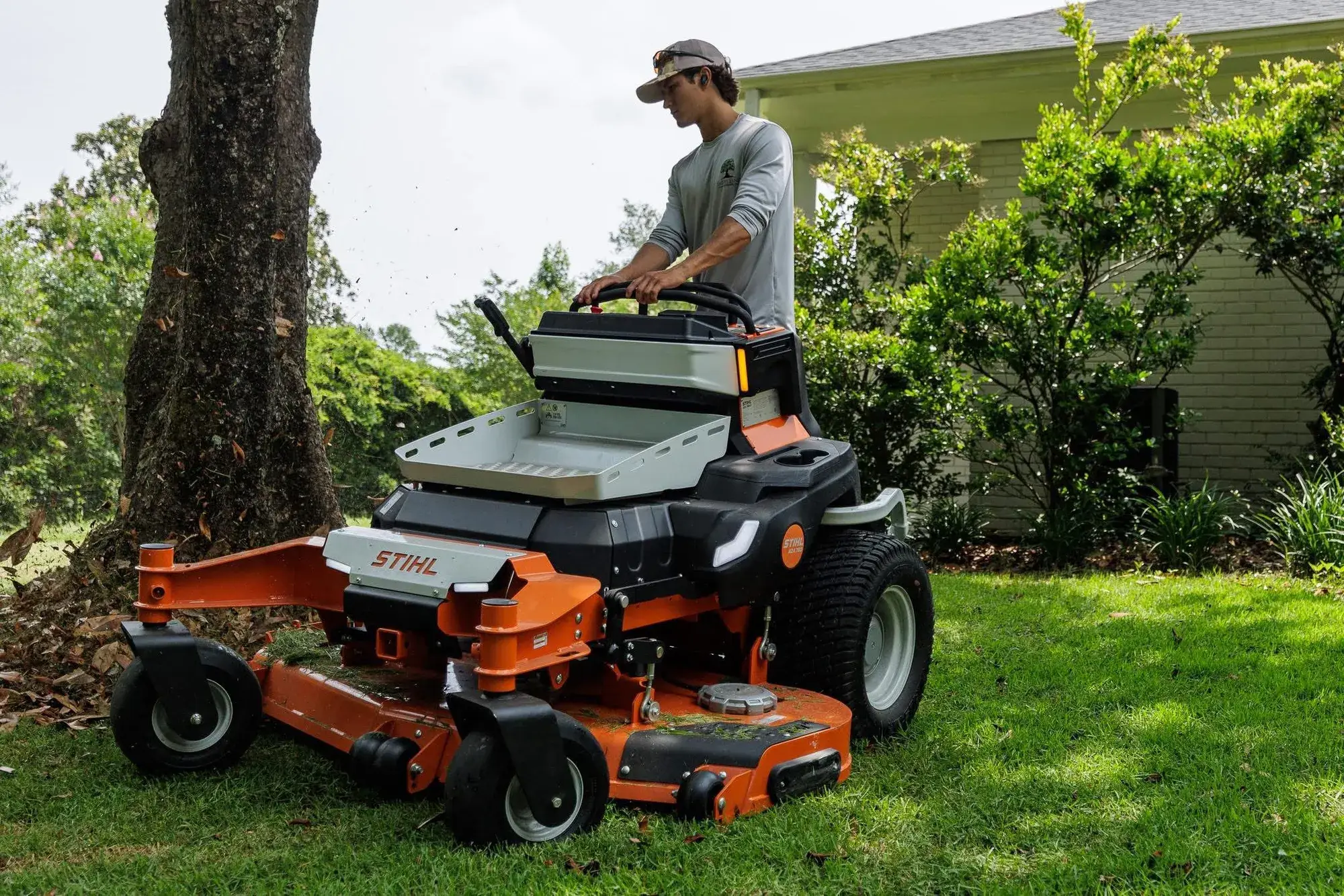 A Smith Land Outdoors crew member mowing with an electric STIHL zero-turn