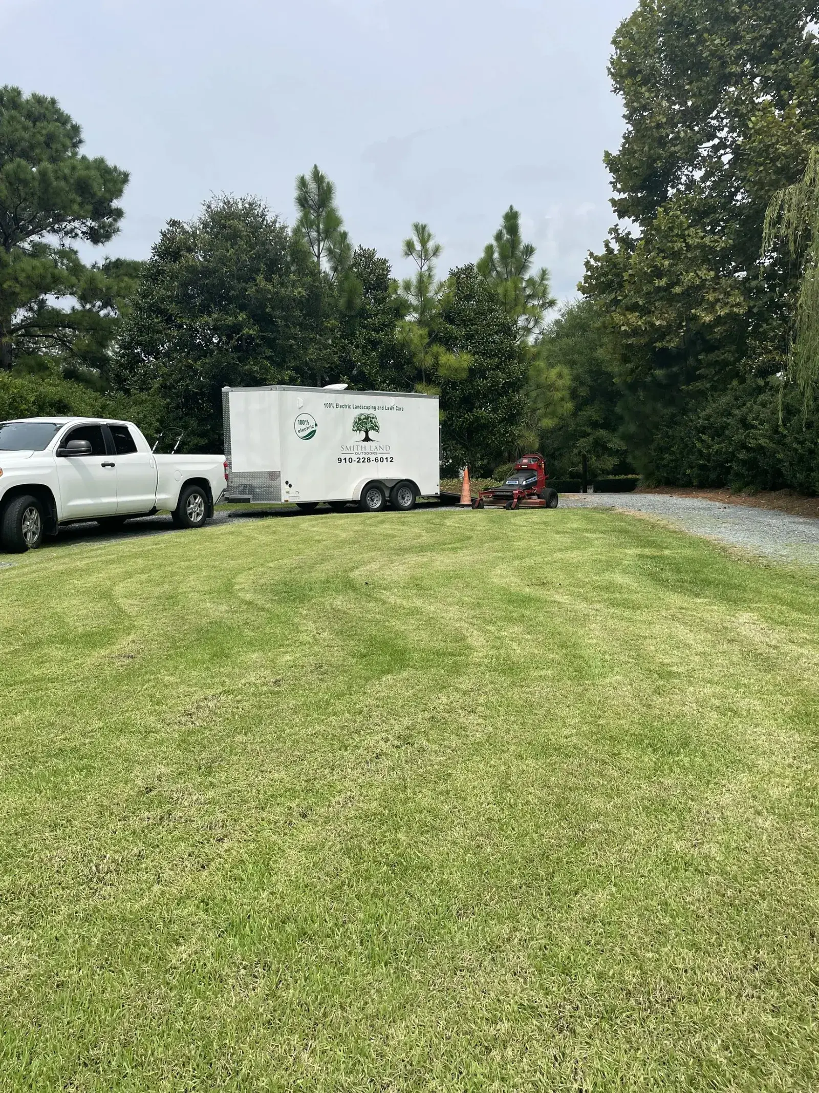 Freshly cut lawn with the Smith Land Outdoors truck and trailer on site
